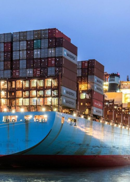 A huge cargo ship moored in Hamburg's harbor during the evening, showcasing global logistics.