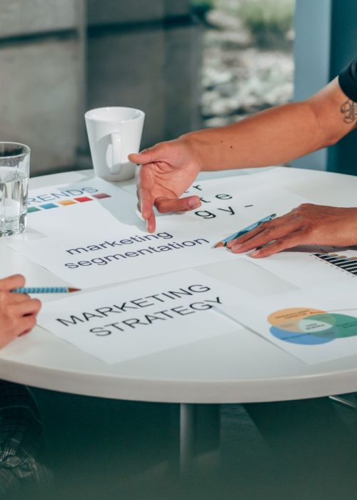Two adults in an office discussing marketing strategy around a round table.